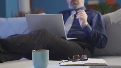 Close-up-of-businessman-looking-at-computer-screen-at-home.